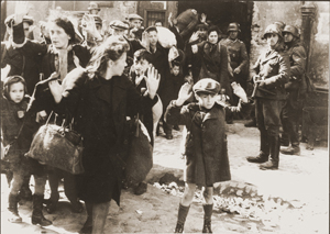 Szene aus dem Warschauer Ghetto. Der Junge im Vordergrund wurde später identifiziert als Tsvi C. Nussbaum. Quelle: Wikipedia.