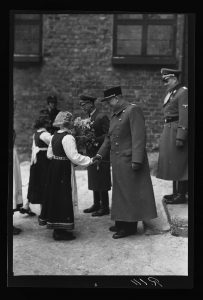 Reichskommissar Josef Terboven, Vidkun Quisling und der Gebietskommissar für Nordnorwegen Paul Wegener werden von Mädchen in norwegischer Tracht vor der Festung Akershus in Oslo begrüßt, 1942. Foto: Henriksen & Steen, Nasjonalbiblioteket.